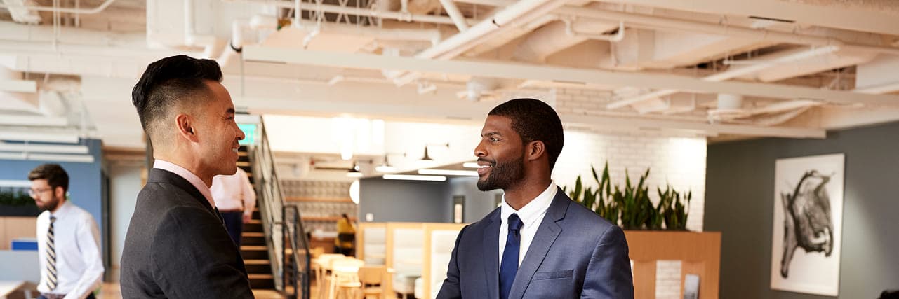 Two professionals shaking hands in a modern office